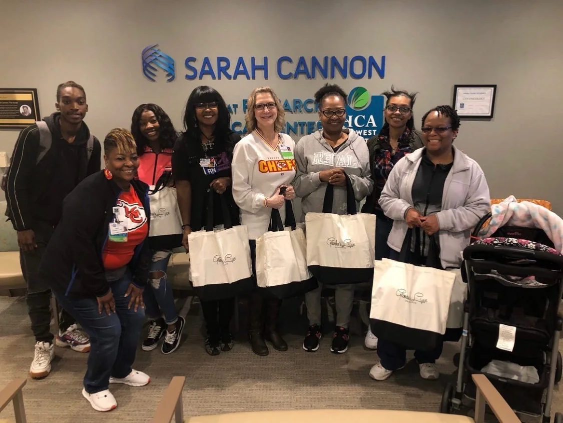 Volunteers and nurses holding Glendra’s Love tote bags at Sarah Cannon Cancer Center